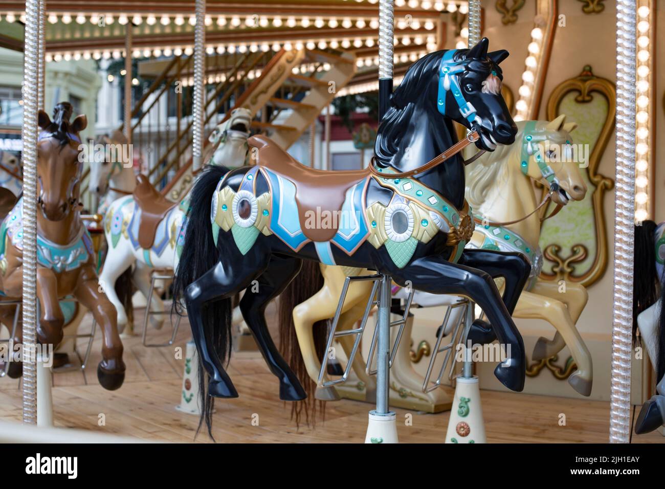 Black plastic horse toy close-up, children carousel fun amusement park Stock Photo