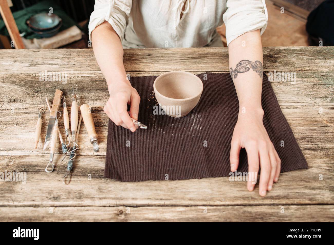 Set of dirty art and craft sculpting tools on wooden table in pottery