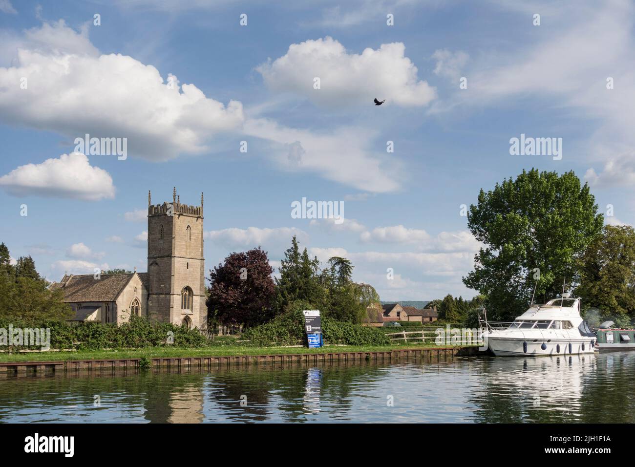 View over St Mary's Church and white boat moored on Gloucester and Sharpness Canal, Frampton on Severn, Gloucestershire, UK Stock Photo