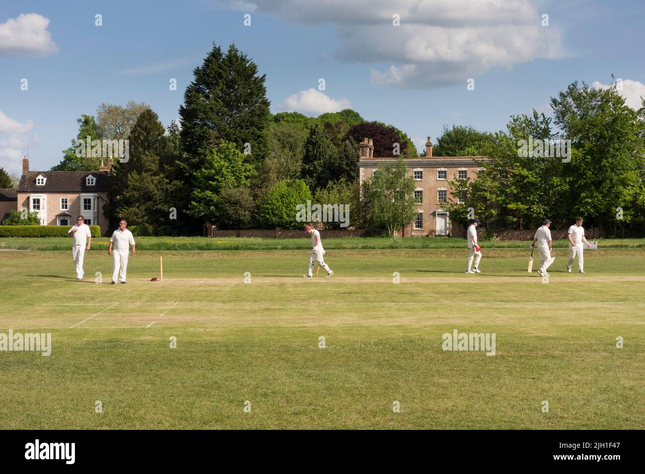 People playing cricket on Village Green, Frampton on Severn, Gloucestershire, UK Stock Photo