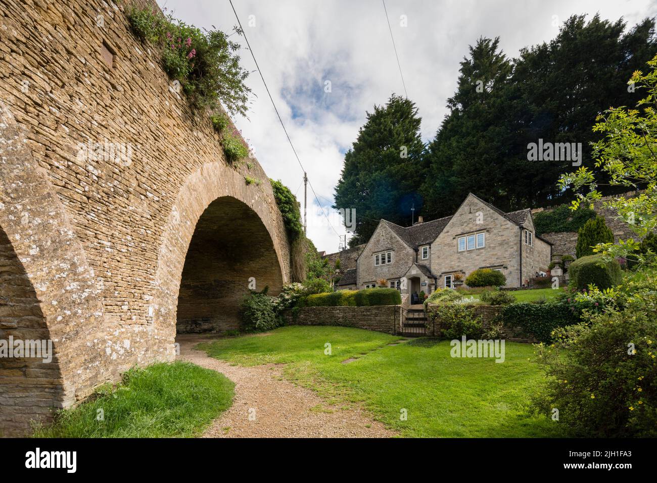 Cotswold stone cottage by viaduct, Tetbury, Gloucestershire, UK Stock Photo