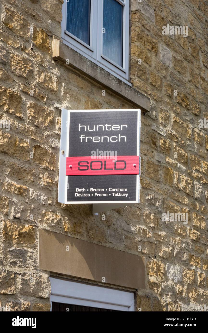 Sold sign by easte agent attatched to wall of house, Tetbury, Gloucestershire, UK Stock Photo