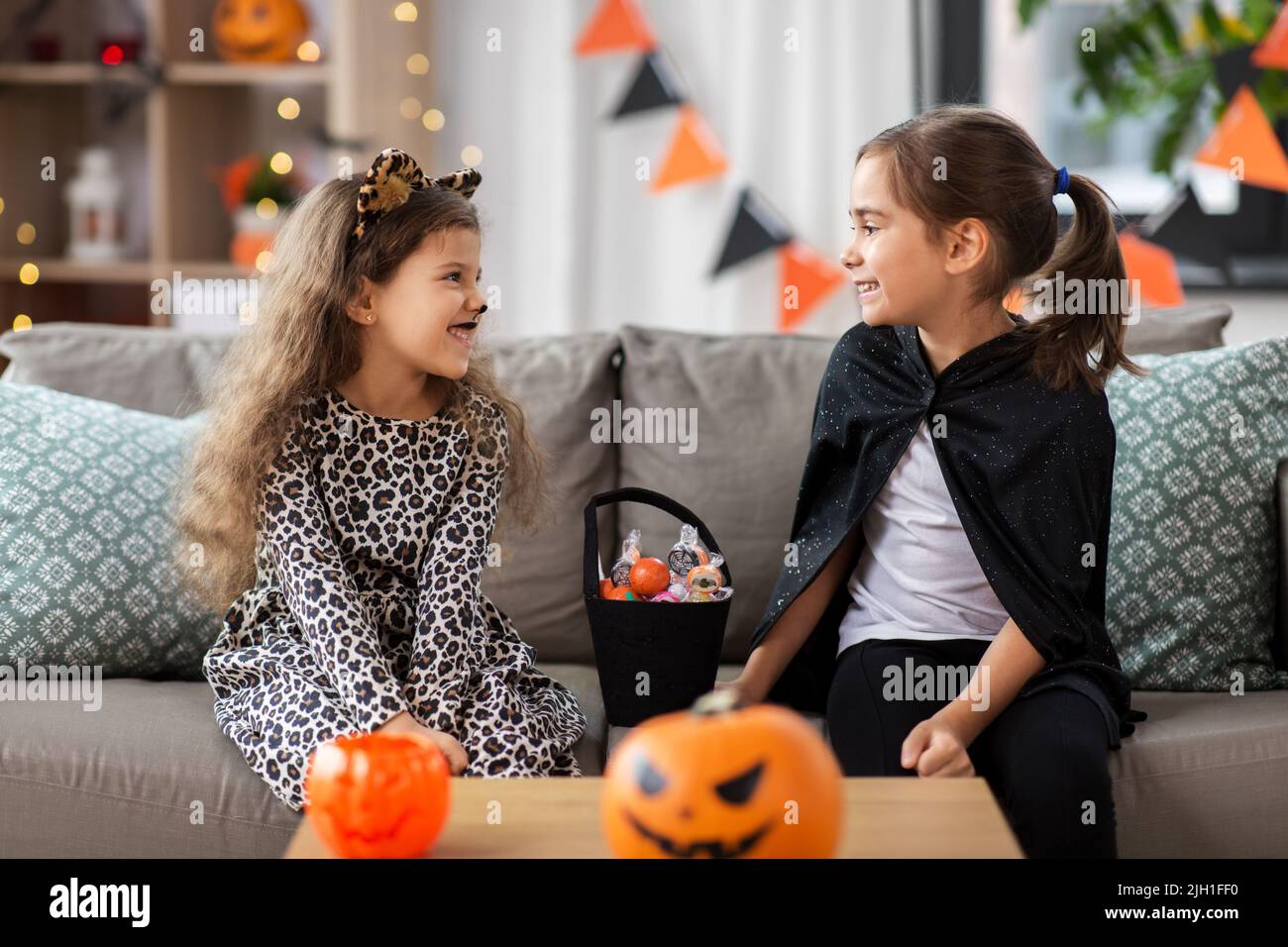 girls in halloween costumes with candies at home Stock Photo - Alamy