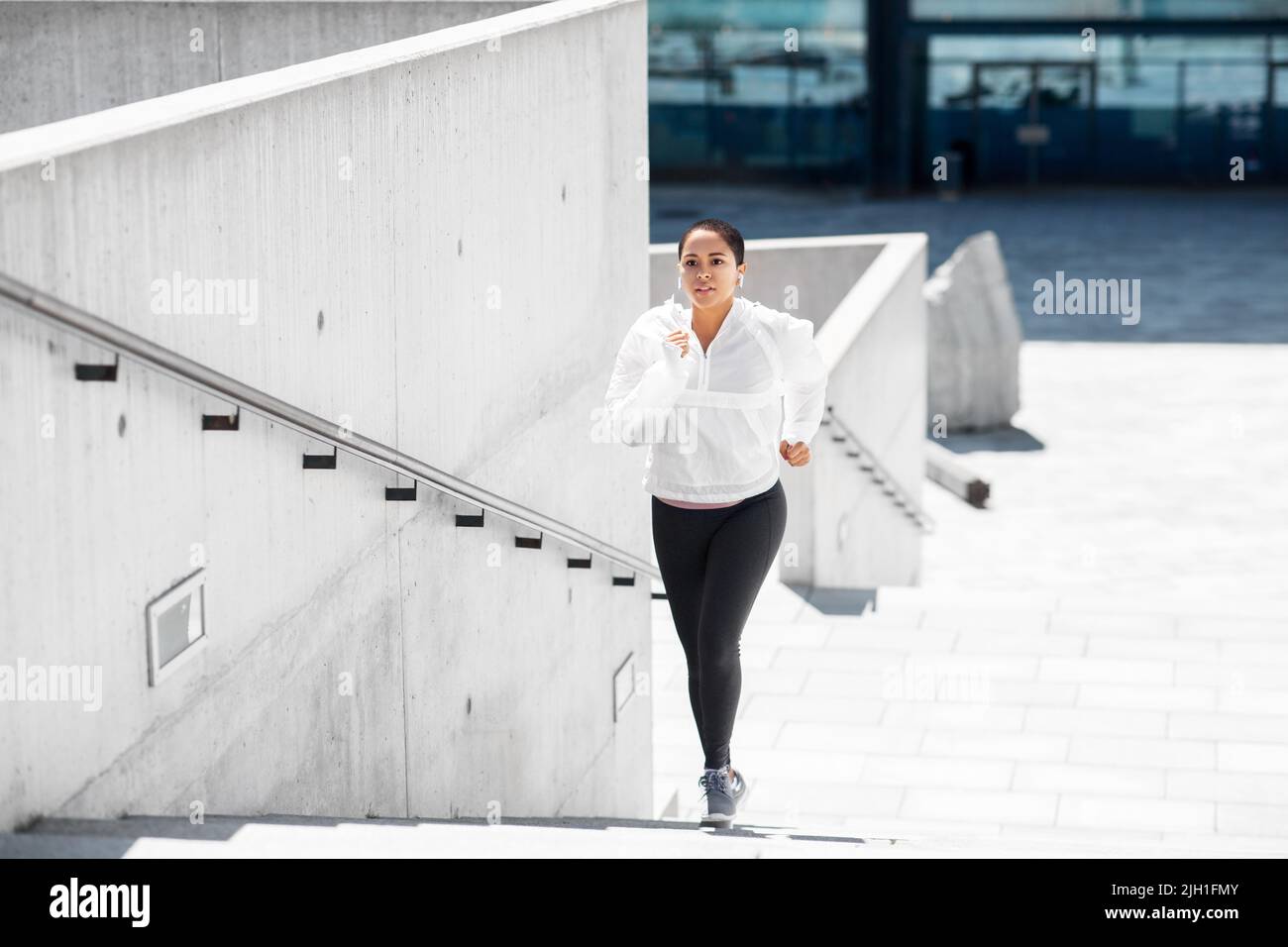 Black woman running up stairs hi-res stock photography and images - Alamy