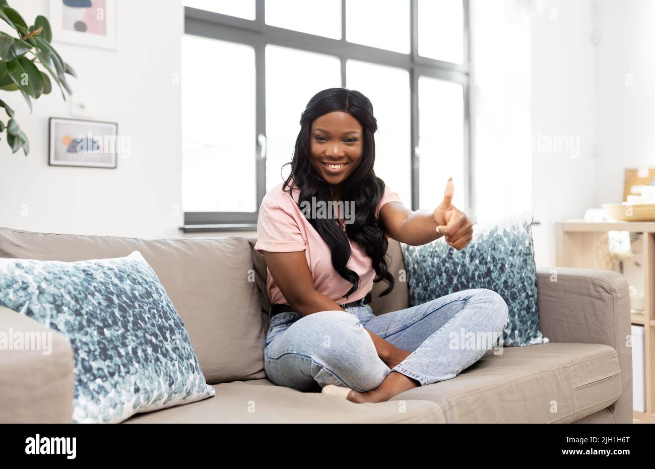 Thumbs up african woman sitting hi-res stock photography and images - Alamy