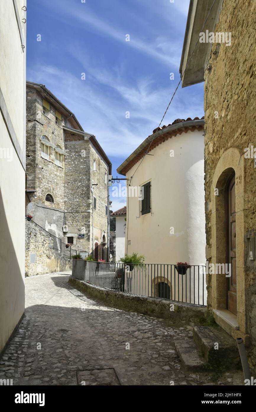 A vertical shot of a narrow paved street between old houses in Fontana ...