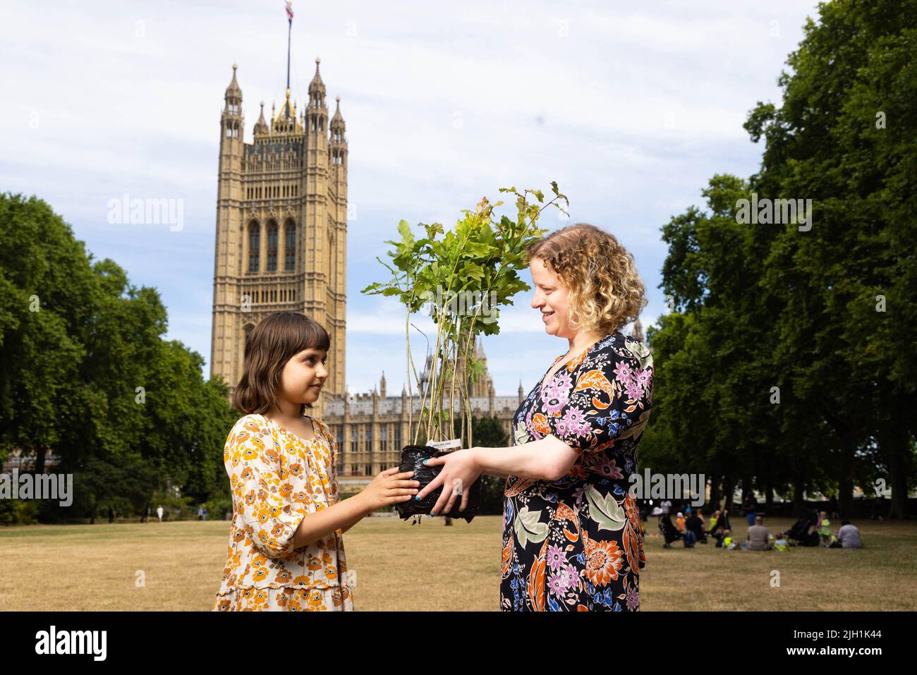 EDITORIAL USE ONLY Olivia Blake MP receives a tree sapling from Aaliya Keegan, 10, from Leicester as members of Zero Hour and various youth groups gather outside the Houses of Parliament ahead of handing in an open letter to all Members of the House of Lords asking Peers to back the Climate and Ecology Bill ahead of its second reading debate on 15 July 2022. Picture date: Thursday July 14, 2022. Stock Photo