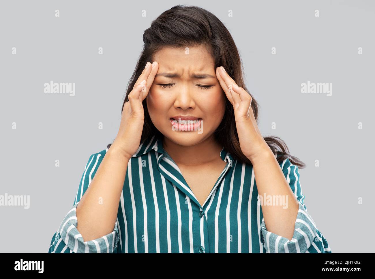 stressed asian woman holding to her head Stock Photo - Alamy