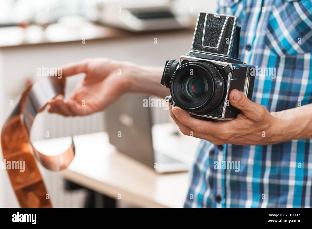 Photographer standing with retro camera and film Stock Photo Alamy