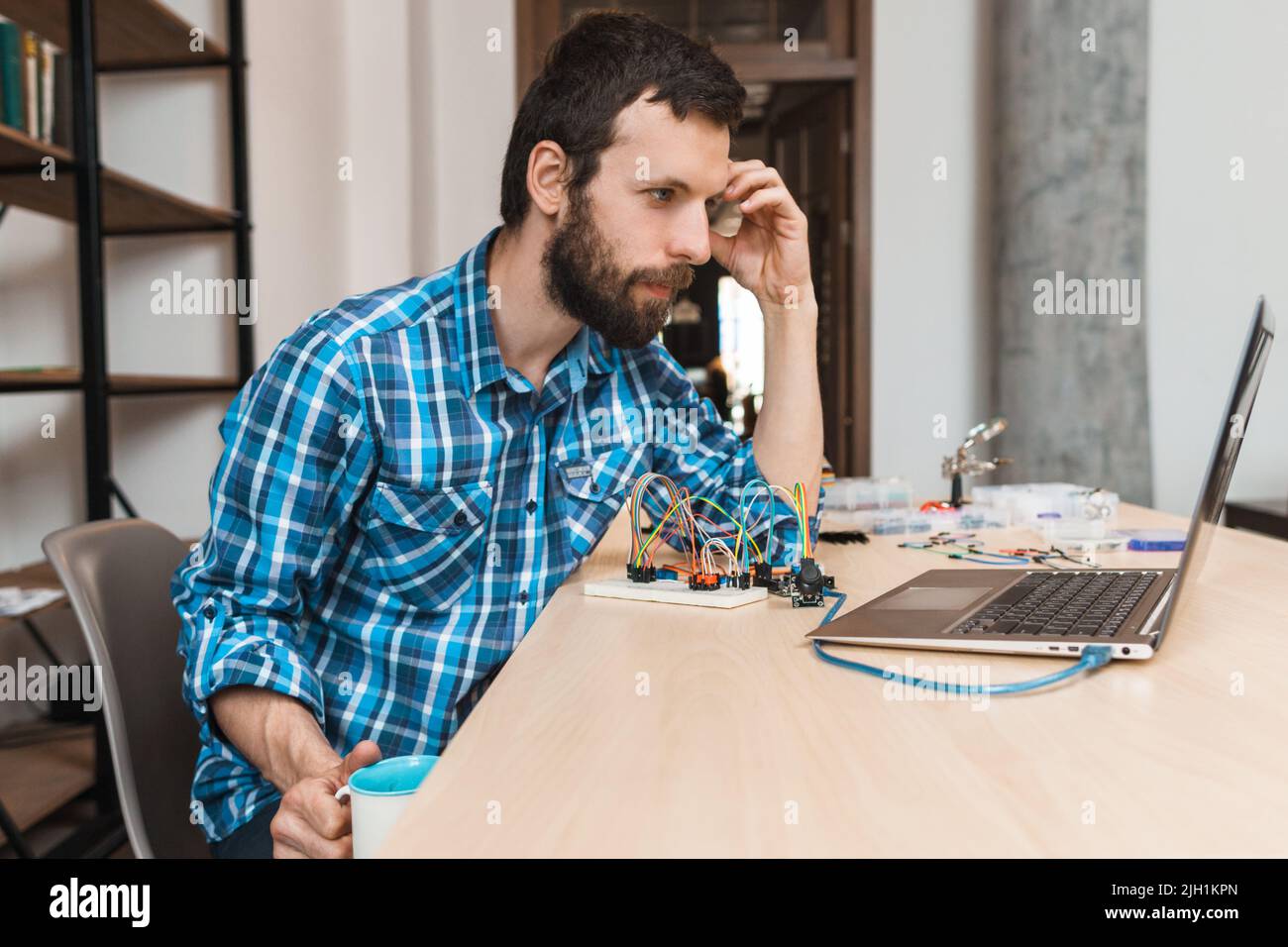 Bearded engineer waiting for program download Stock Photo