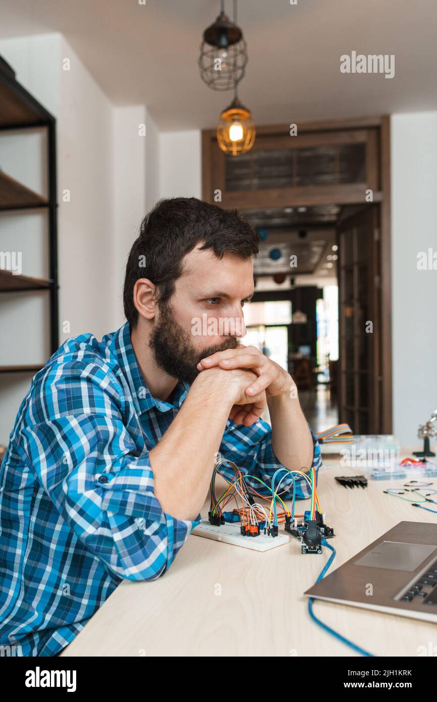 Concentrated programmer looking at laptop screen Stock Photo