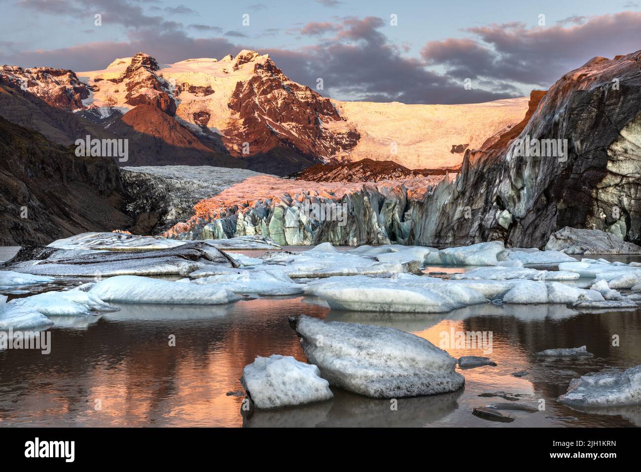 Warm sunlight across the ice and mountains of Svinafellsjokul glacier at sunset., southern iceland. Part of the larger Vatnajokull glacier, the larges Stock Photo