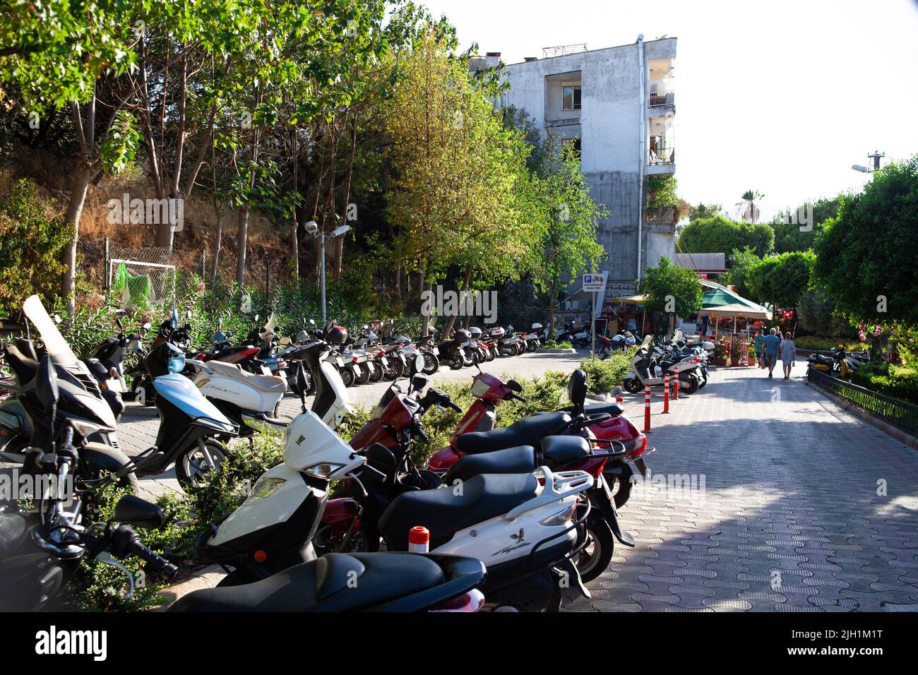 Scooters, motorcycles and mopeds in the street Parking on a Sunny