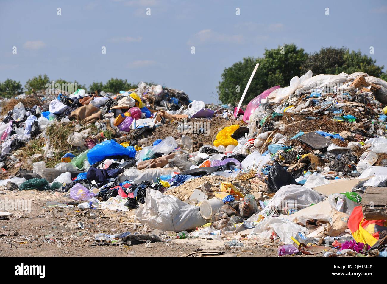 Big pile of unsorted garbage under the sun in municipal landfill in summer day, selective focus Stock Photo