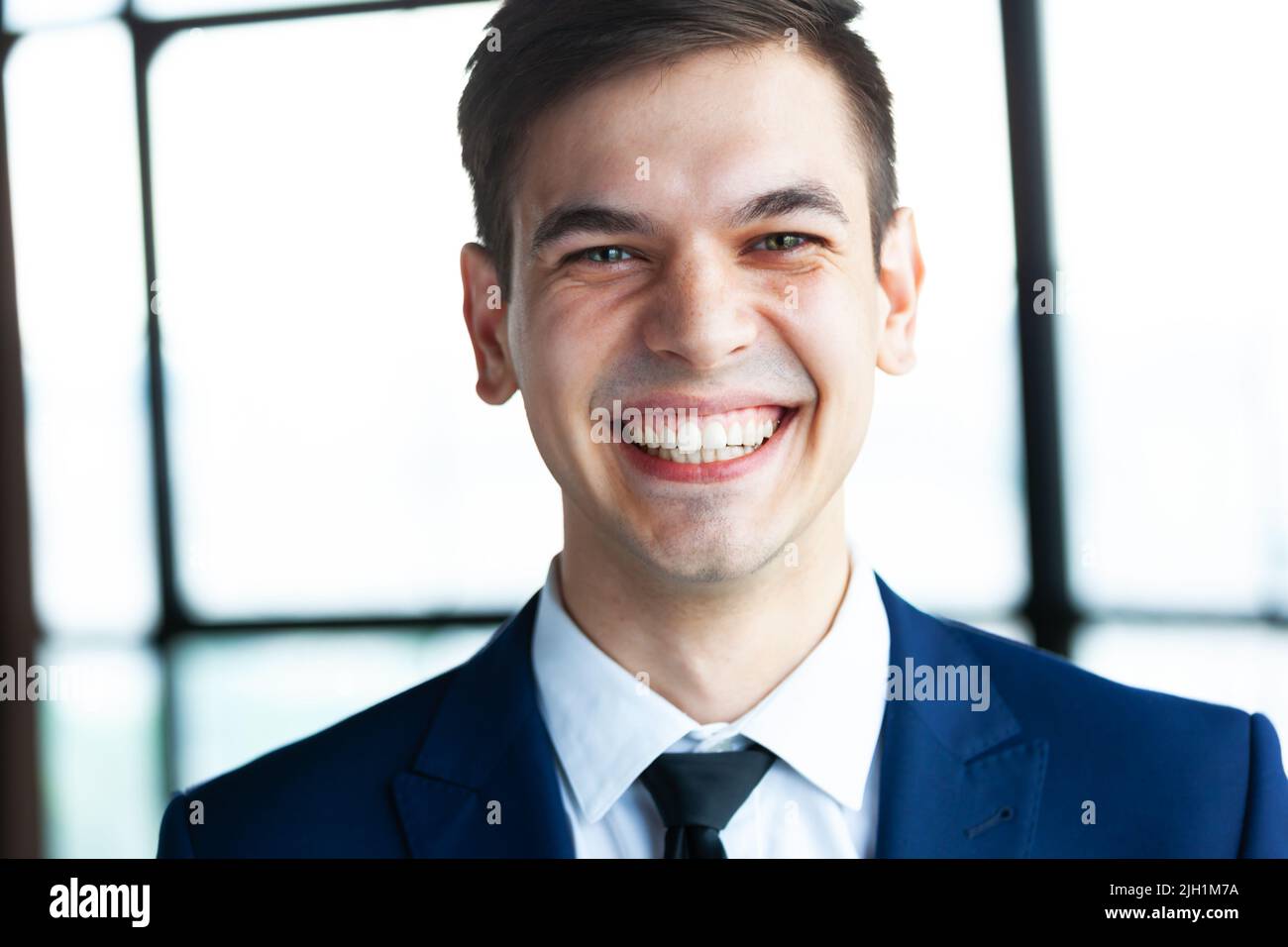 Portrait of a young happy handsome businessman looking at camera. Stock Photo