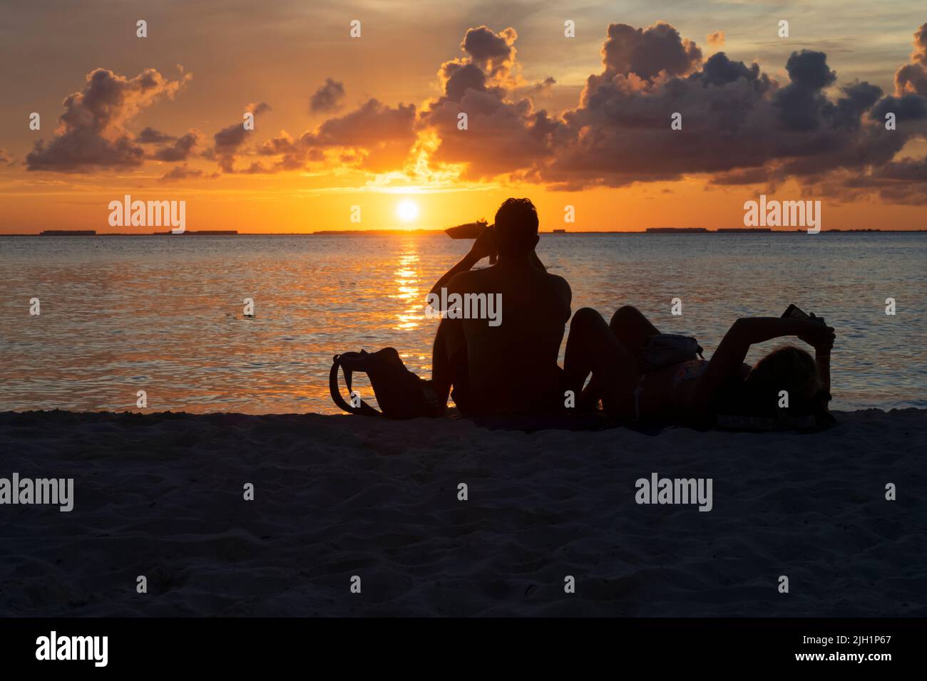 Silhouette of a tourist couple at sunset on a tropical island beach at sunset in Mexico Stock Photo