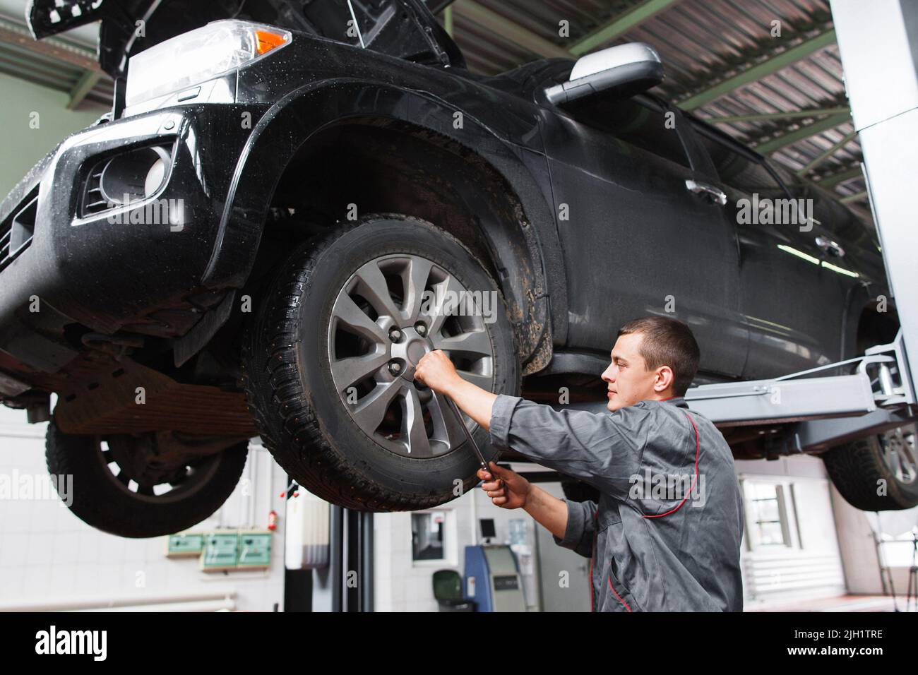 Mechanic diagnosting car wheel with screwdriver Stock Photo Alamy