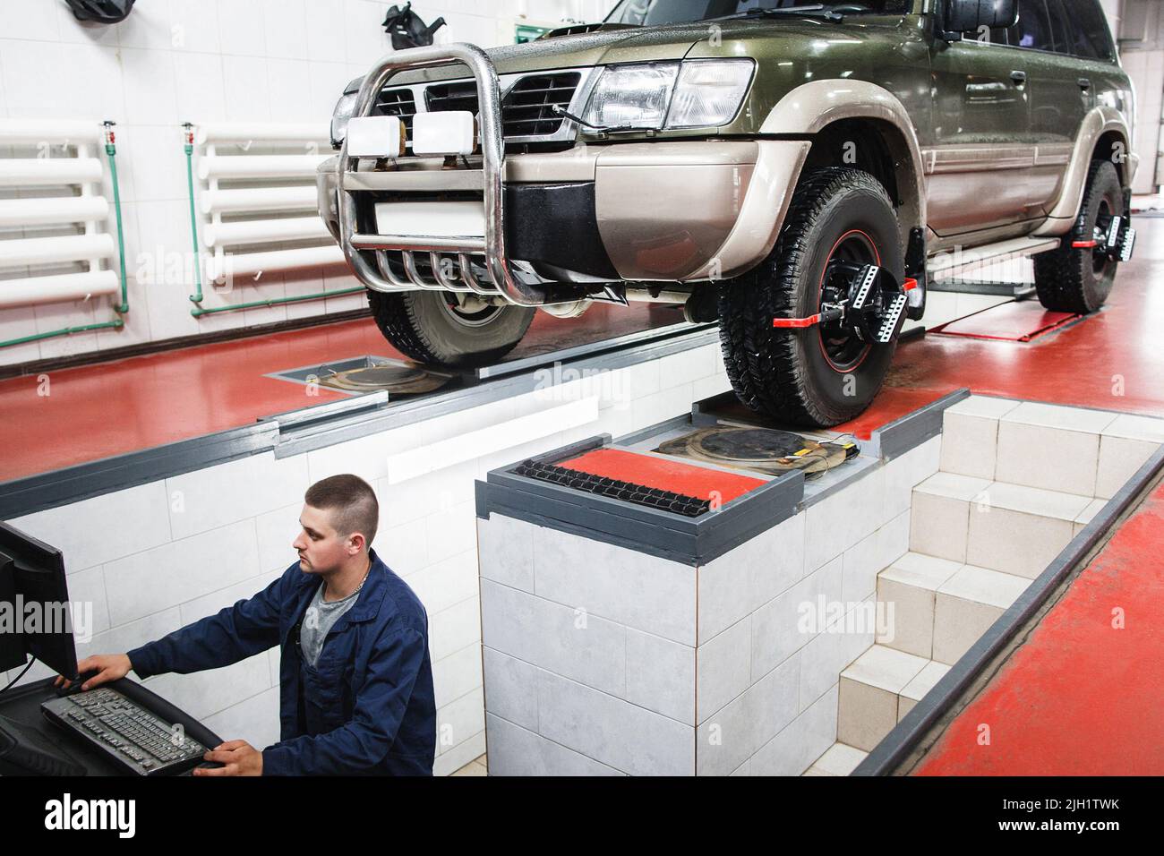 SUV undergoing auto wheel alignment in garage Stock Photo