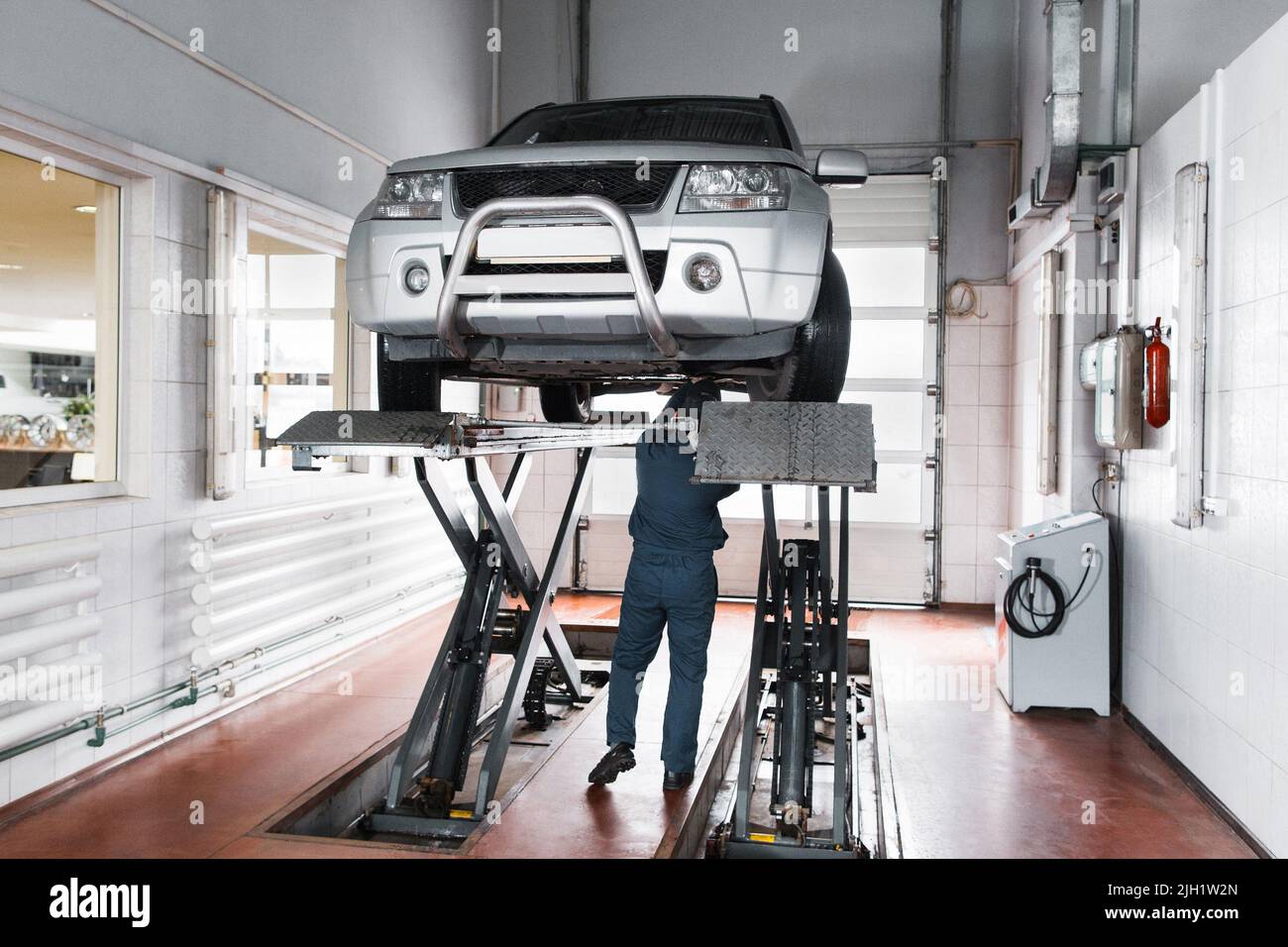 Mechanic inspect suspension system of lifted car Stock Photo Alamy