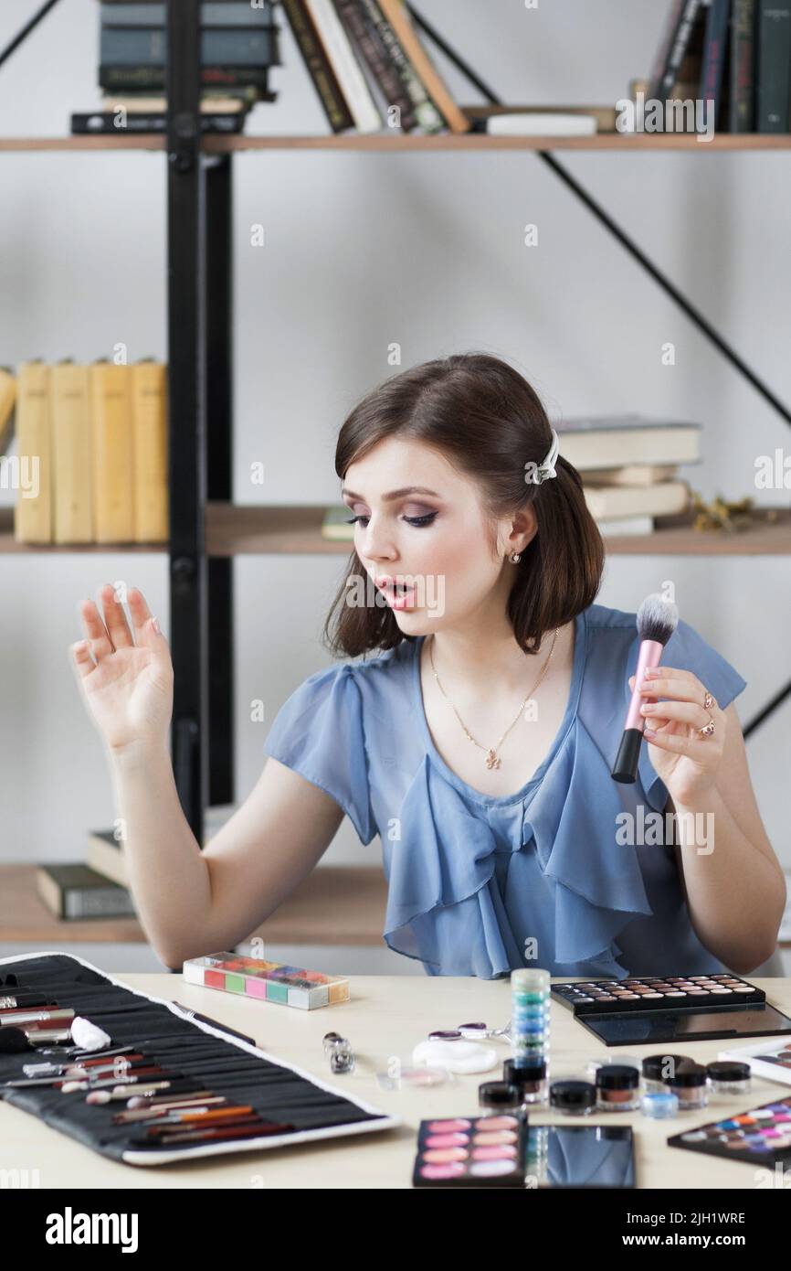 Emotional woman choosing brush for makeup Stock Photo