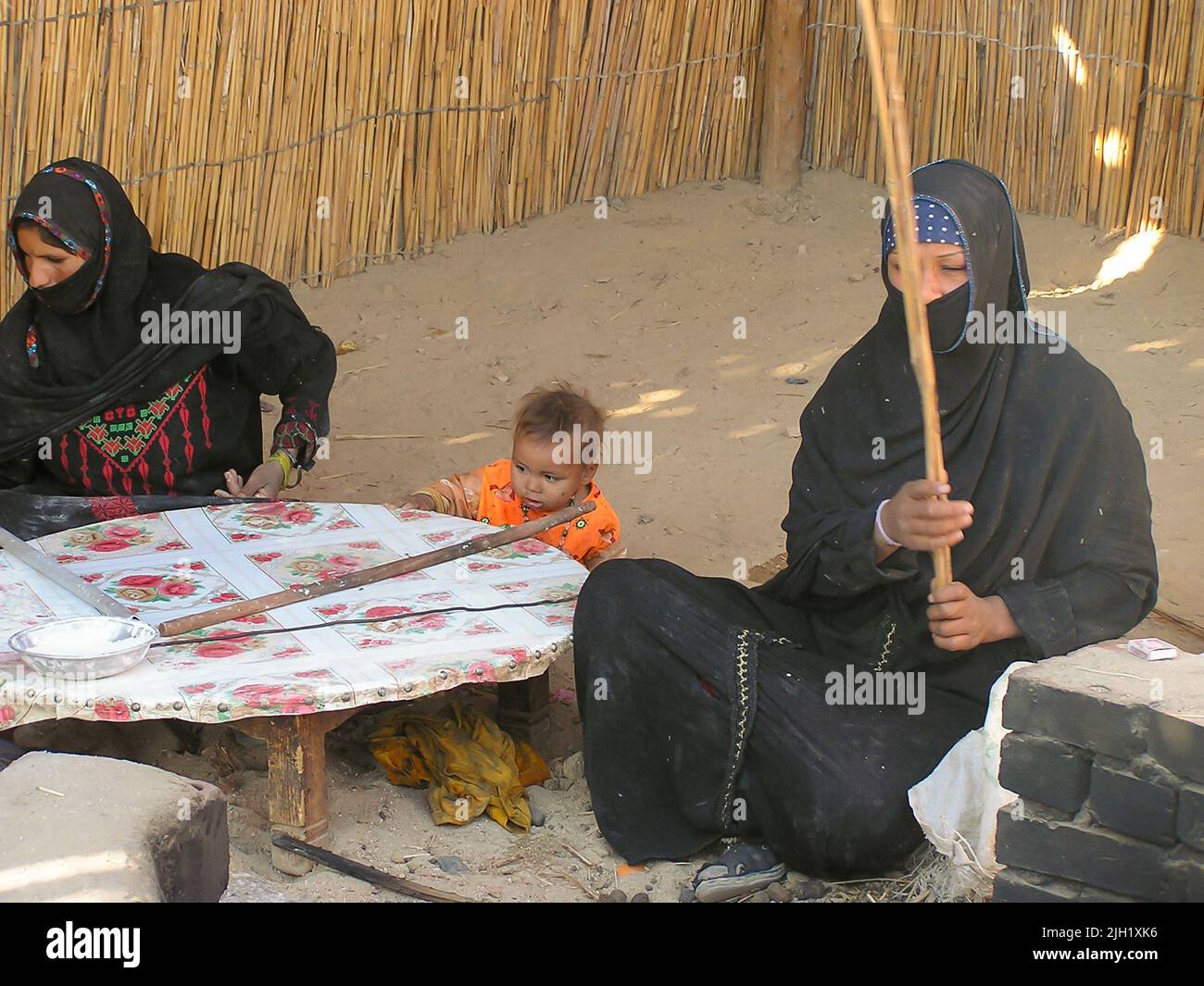 bedouins women making breads for tourists and selling crafts under  a tent in Sahara desert. Sahara, Egypt. Stock Photo