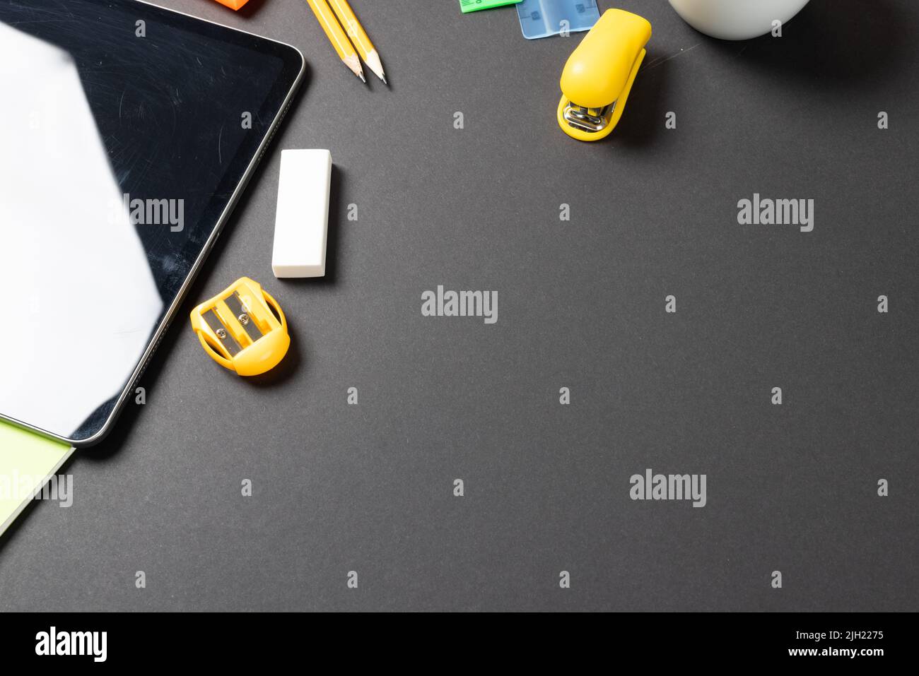 Imagine of various office supplies, pins, rulers, scissorson and tablet