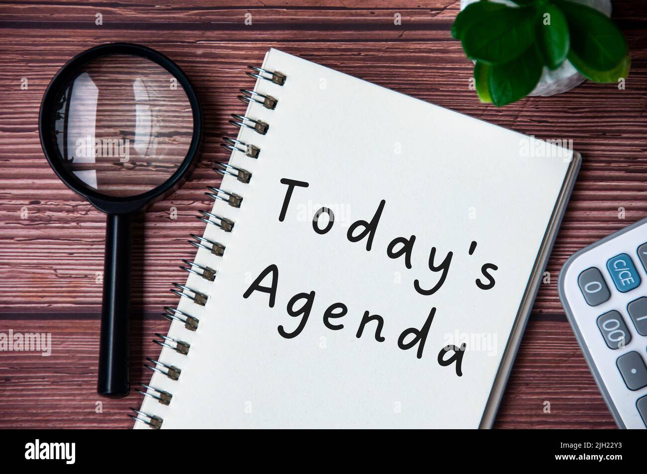 Today's agenda text on notepad. Magnifying glass and calculator ...