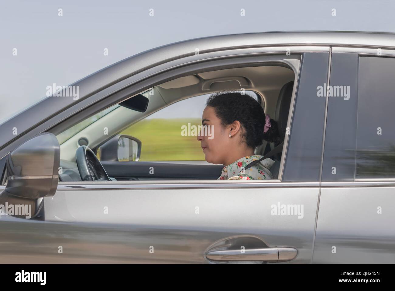 Side shot of woman driving a car Stock Photo