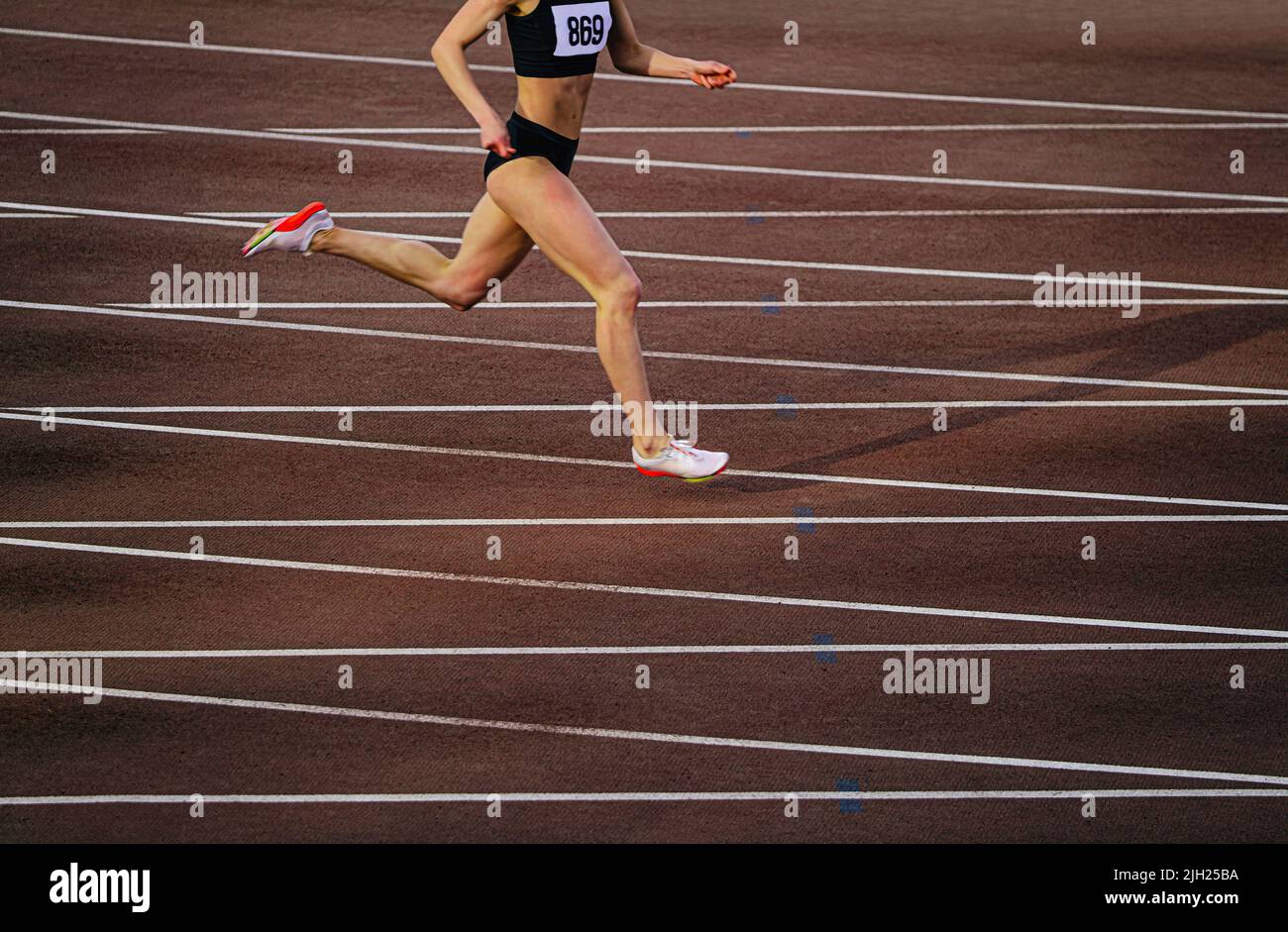 A young female / woman athlete wearing running sports clothing is