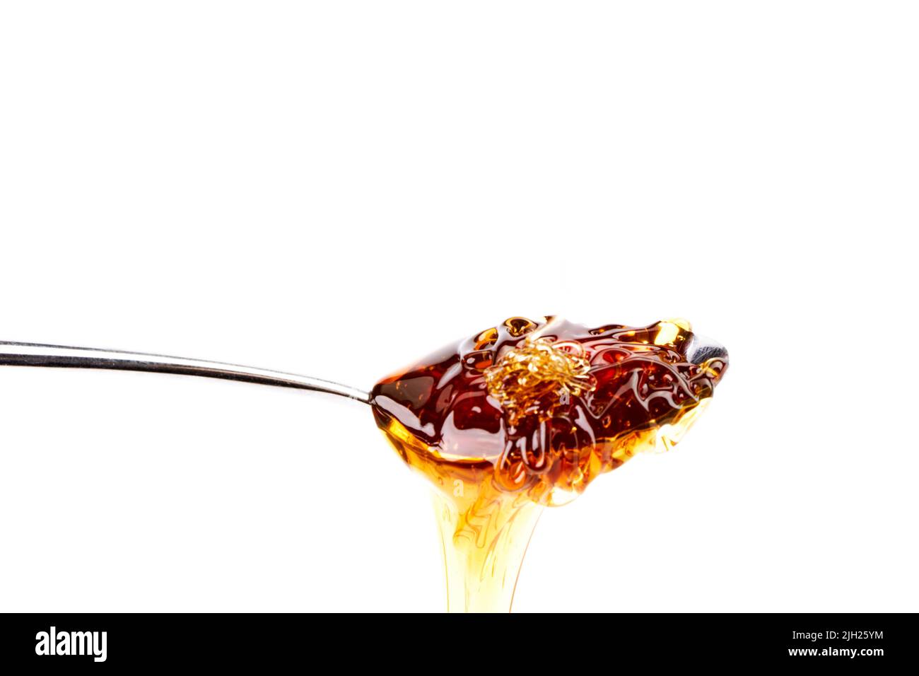 Tasty honey dripping from a teaspoon. Healthy and organic food Stock Photo