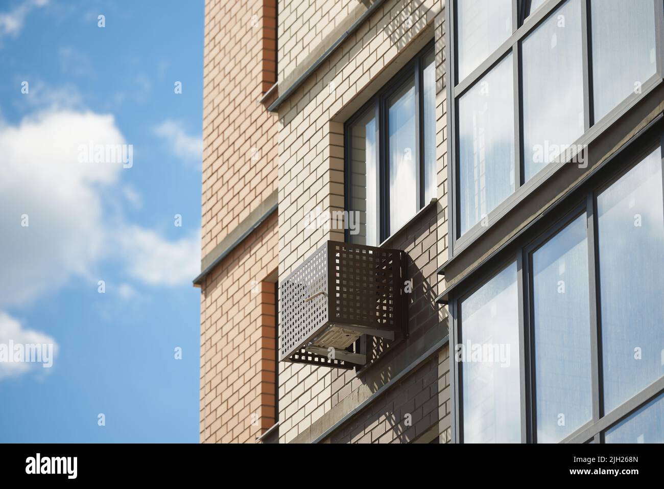 Facade of apartment building with decorative air conditioner covers. Stock Photo