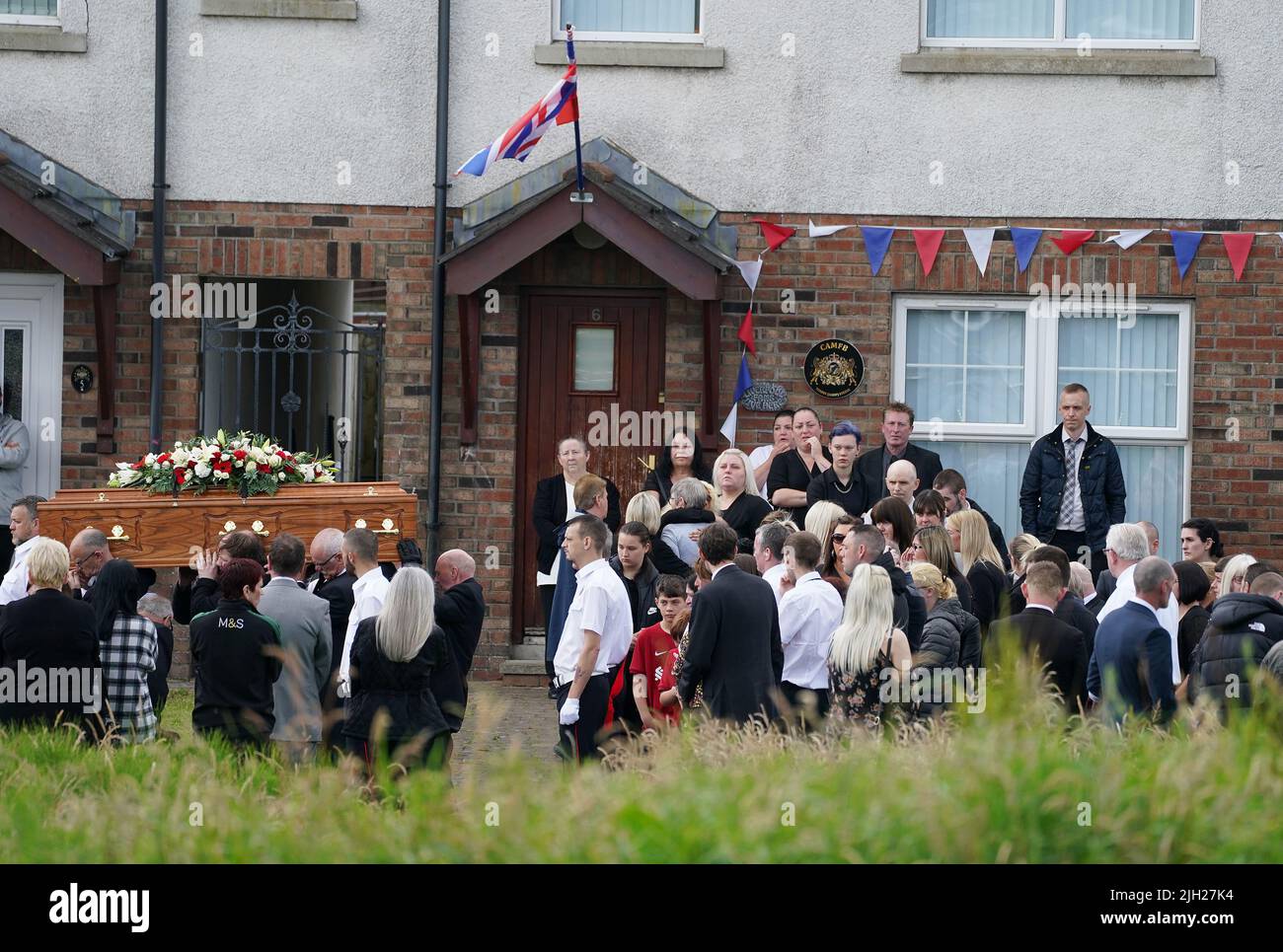 The coffin of John Steele is carried by mourners following his funeral service at his house in Larne, County Antrim. Mr. Steele fell to his death on Saturday while helping to build a bonfire. Picture date: Thursday July 14, 2022. Stock Photo