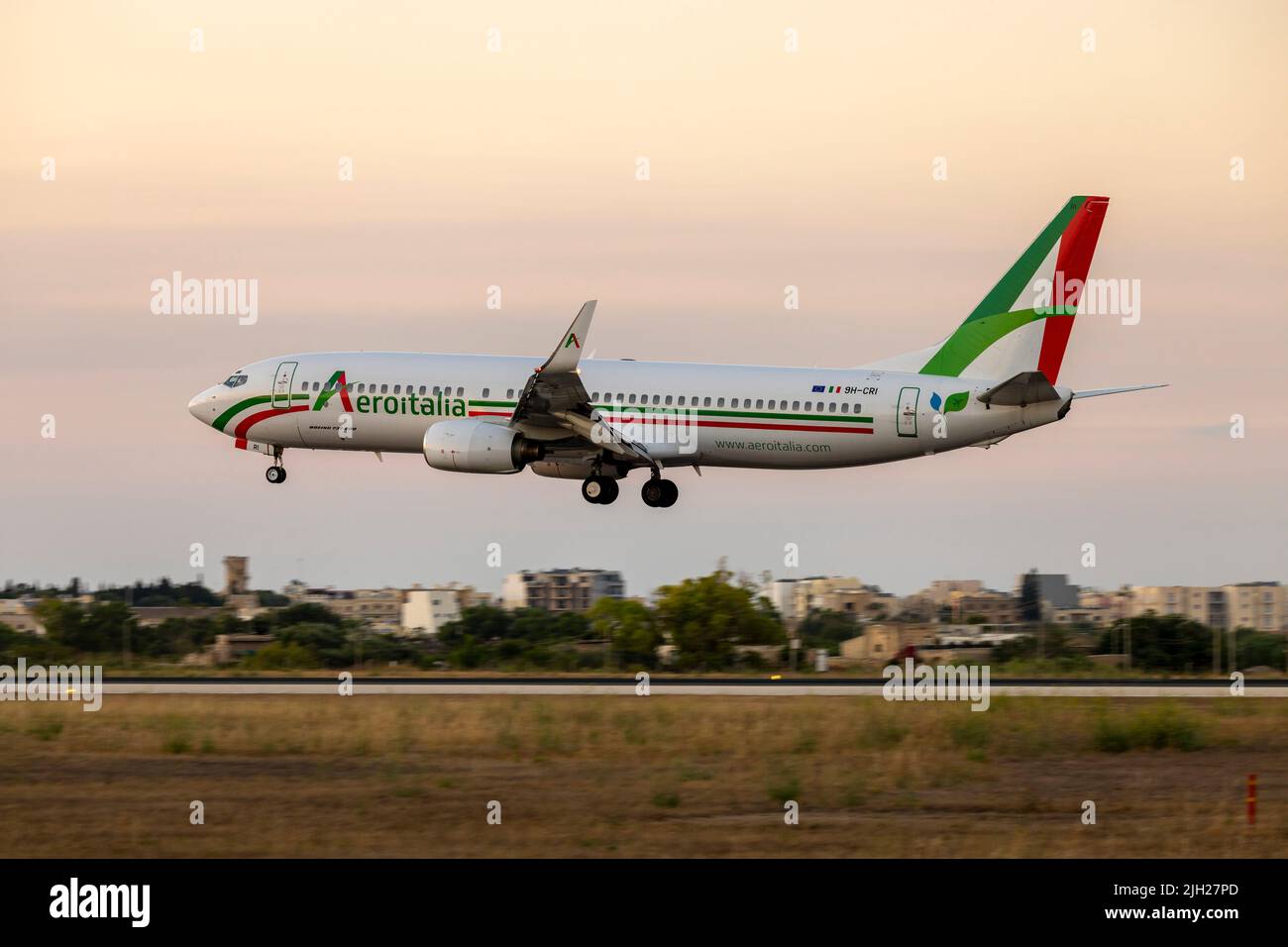 Aeroitalia Boeing 737-85F (REG: 9H-CRI) starting scheduled flights for summer, arriving after sunset. Stock Photo