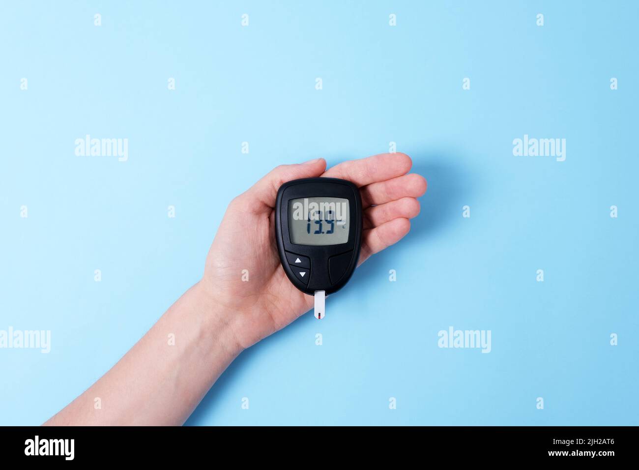 Hand holding a Diabetes concept on light blue background