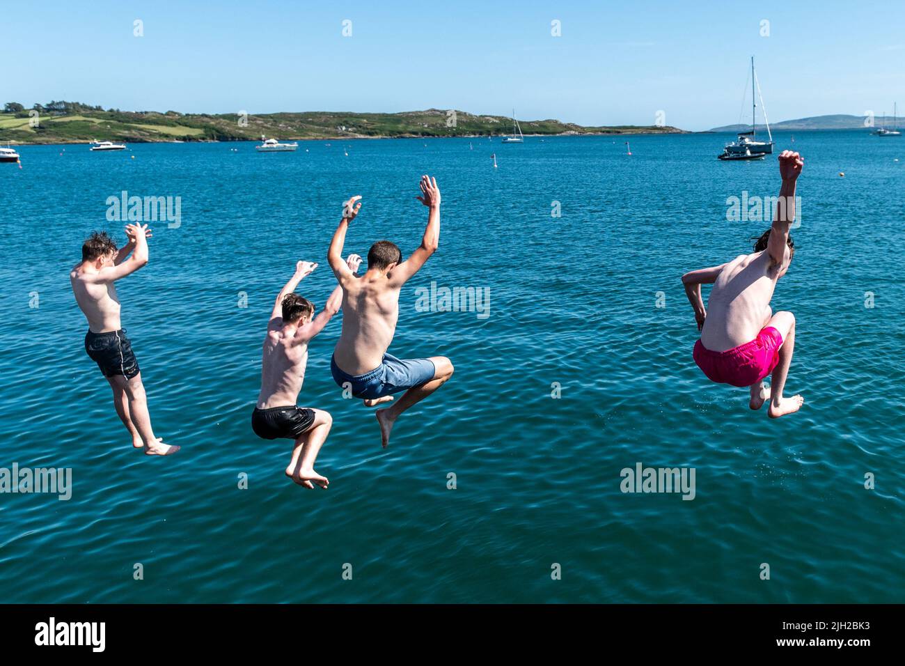 Schull, West Cork, Ireland. 14th July, 2022. The temperatures in West Cork hit 23C today, with many people heading for the coast to cool off. Jumping off Schull pier to cool down were Robert Collins, Skibbereen; Conor Lawson, Schull; Jackson Little, Ballydehob and Dylan Crowley, Mealagh Valley. Credit: AG News/Alamy Live News Stock Photo