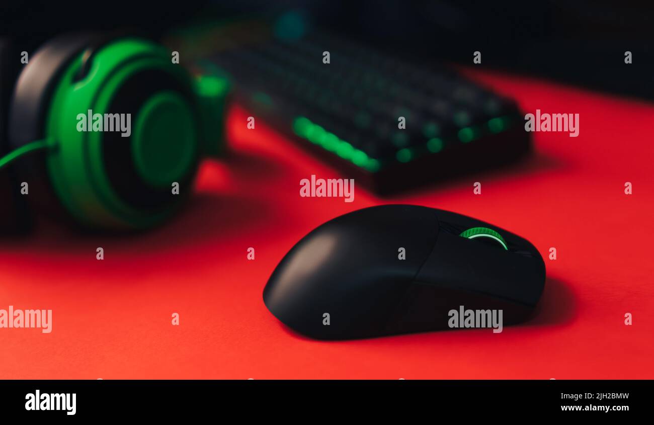 Computer gaming mouse and keyboard and green hedset on red background ...