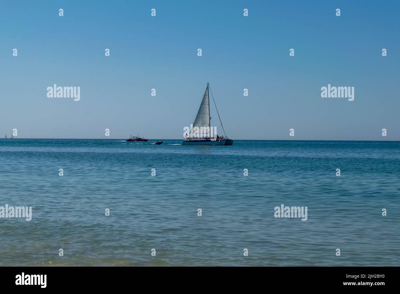 Touristic boats cruising on summer time in the ocean. Boats on the sea. Nautical activities, tourism on coastal locations. Boat tours. Stock Photo