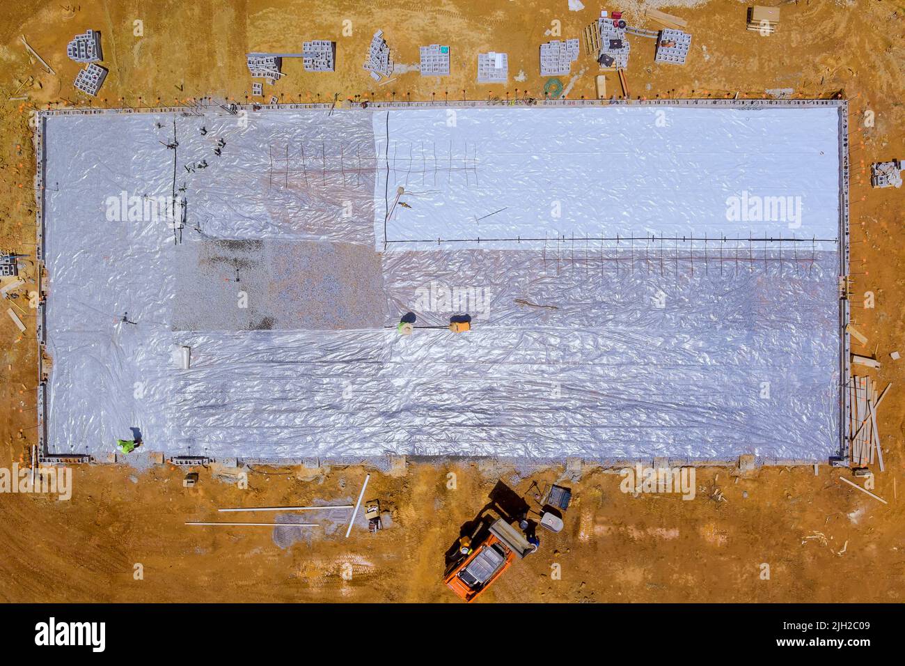 Installing barrier plastics before pouring concrete on the foundation