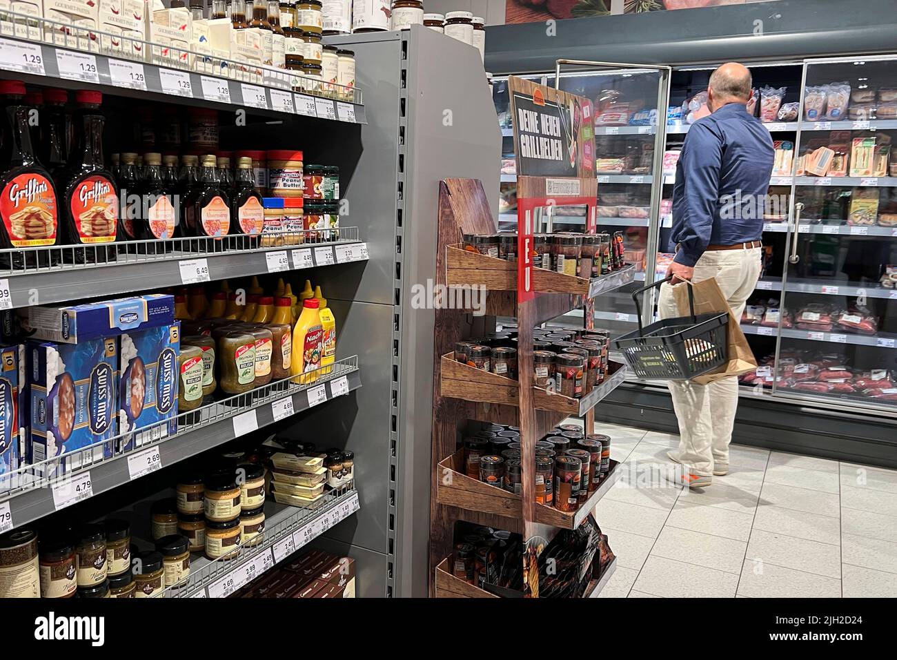 Munich, Germany. 14th July, 2022. Munich, Deutschland. 14th July, 2022. CONSUMER PRICES: Inflation in Germany A man stands in front of a refrigerated shelf and looks spellbound at the prices, price tag, price display, refrigerated counter, meat and sausage products. Purchasing, inflation, consumer prices, Credit: dpa/Alamy Live News Credit: dpa picture alliance/Alamy Live News Stock Photo