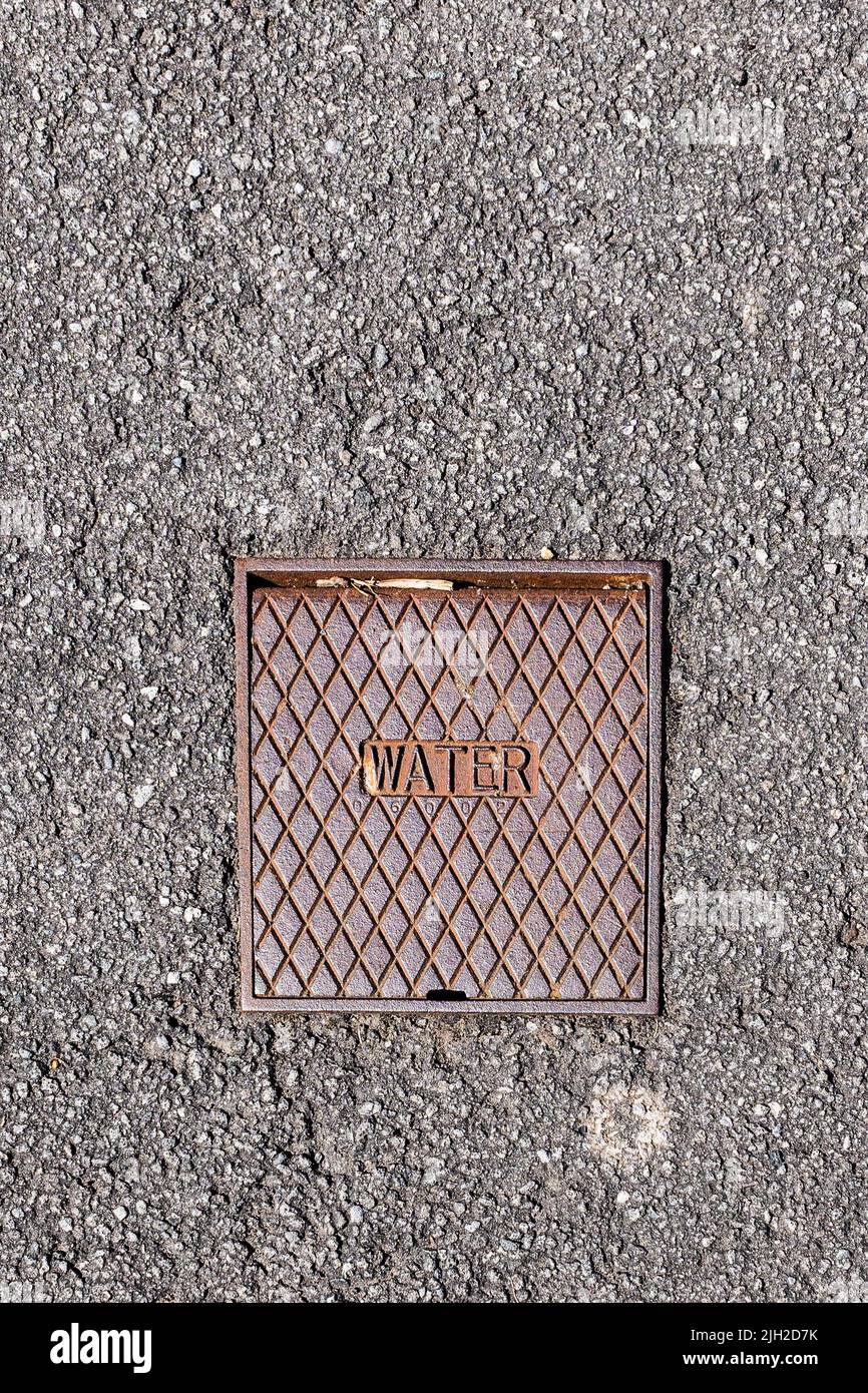 An outside stopcock with metal cover to access mains water supply. UK water security. Space for text. Magazine, Poster. Stock Photo