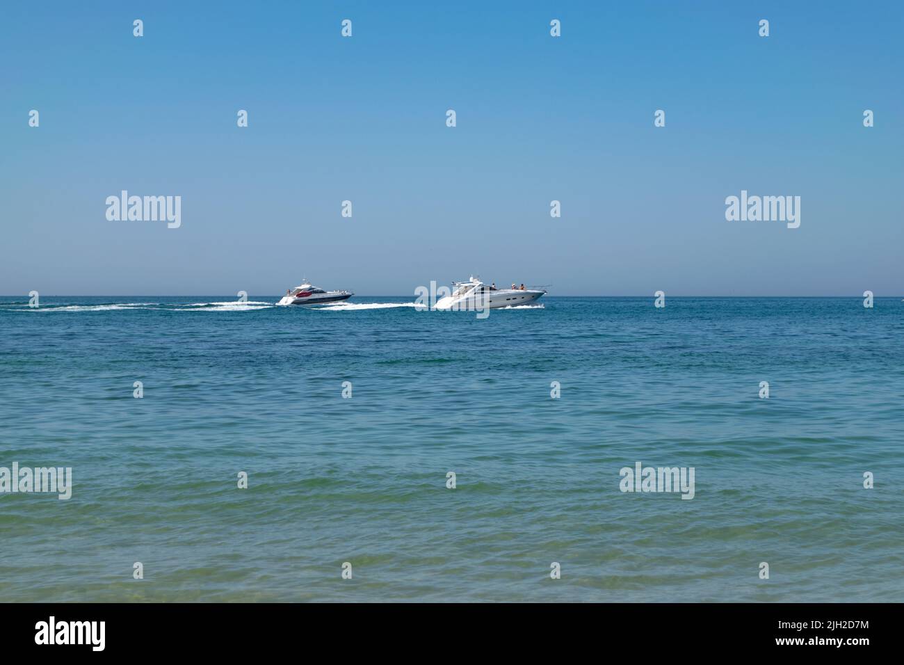 Touristic boats cruising on summer time in the ocean. Boats on the sea. Nautical activities, tourism on coastal locations. Boat tours. Stock Photo