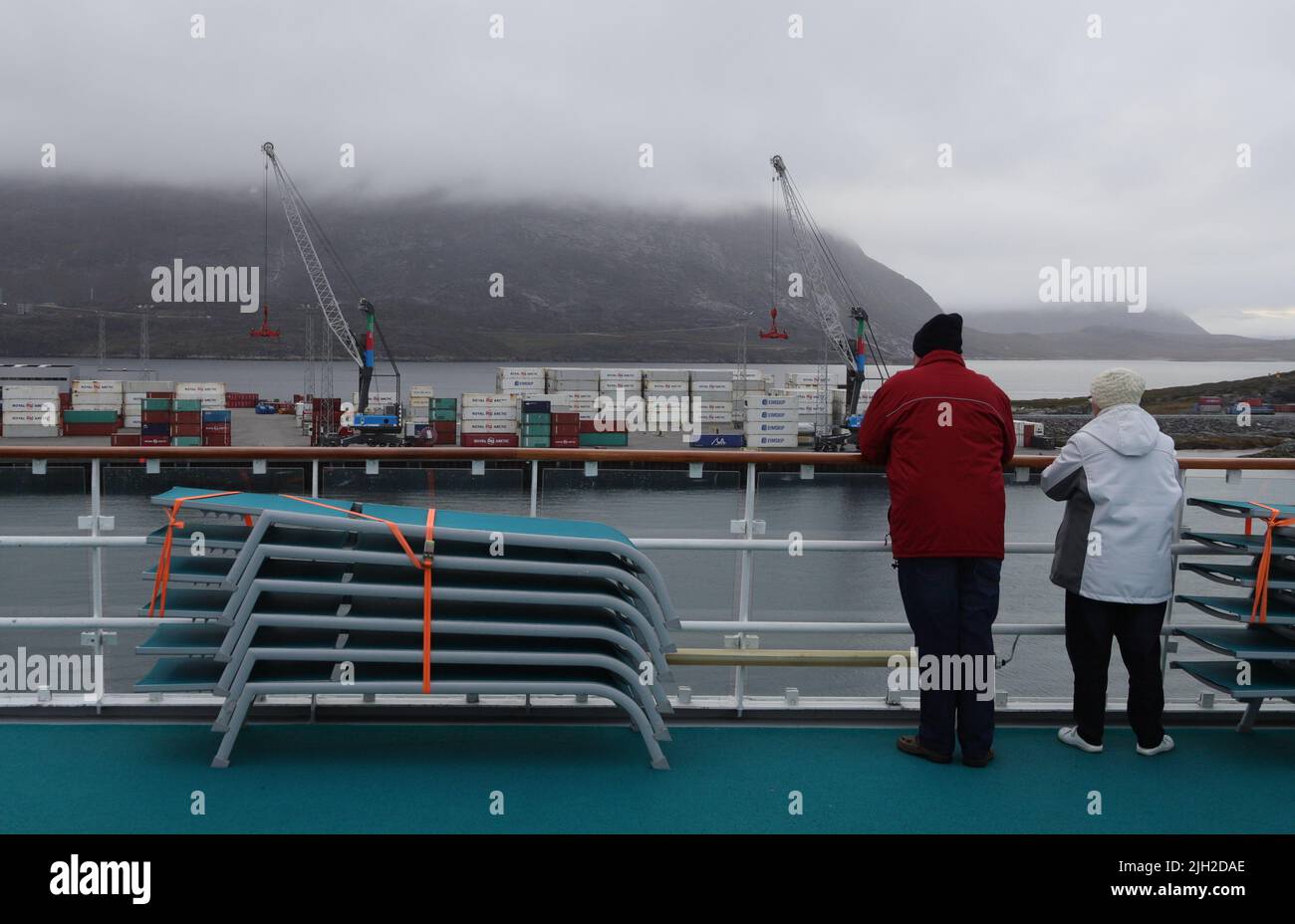 Grönland, Nuuk: Passagiere der AIDAcara blicken auf den Containerhafen und einen nebelverhangenen Stadtteil von Nuuk. Stock Photo