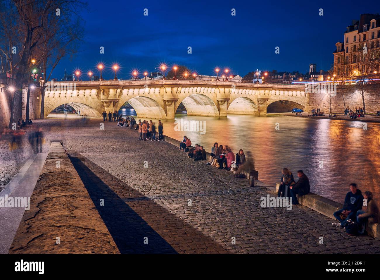People rest on the banks of the Seine river in Paris Stock Photo