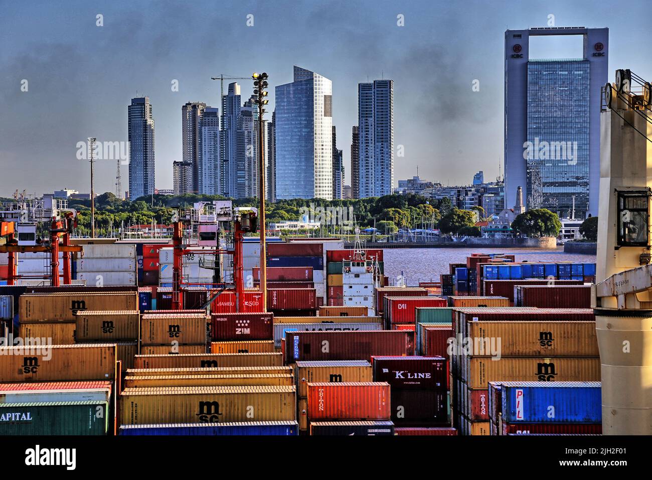Vor der Silhouette von Montevideo mit ihren Aufragenden Hochhäusern liegt der Containerhafen der Stadt. Die Qualmwolke aus dem Schornstein eines Frachters verdunkelt die Sicht. Stock Photo