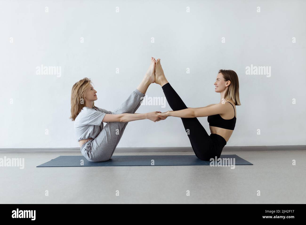 sporty yogi sisters doing fitness training. pair, couple yoga Stock Photo