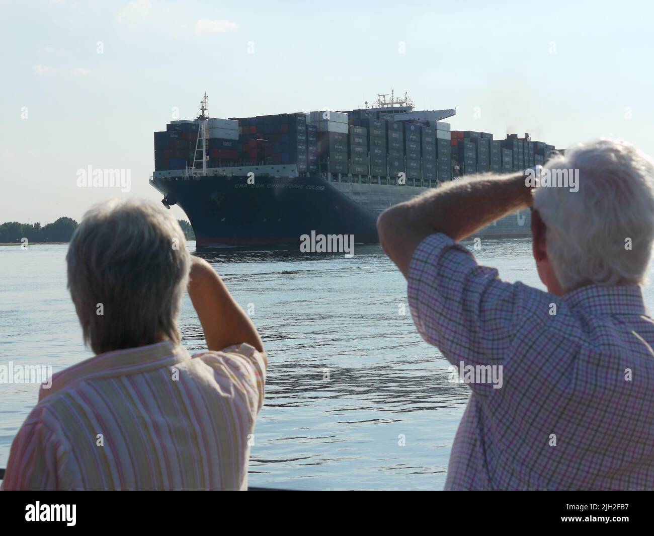 Der Container-Riese CMA CGM Christophe Colomb lief 2010 zum ersten Mal den Hamburger Hafen an. Er war seinerzeit das größte Container-Schiff und wurde von vielen Schaulustigen begrüßt. Ein Feuerlöschboot begrüßt das Schiff mit einer Wasserfontäne. Stock Photo
