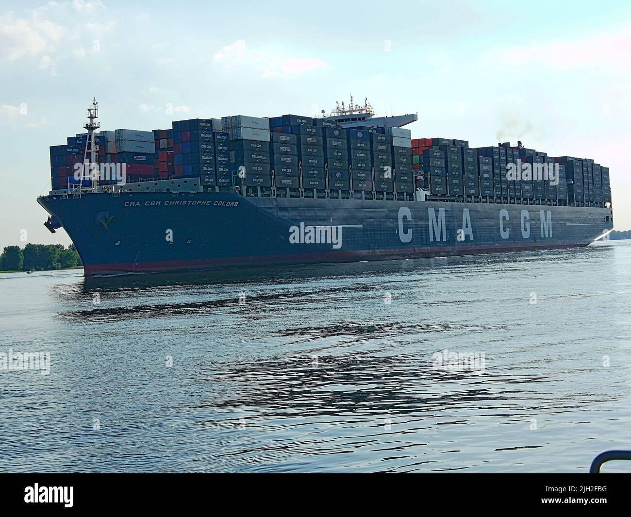 Der Container-Riese CMA CGM Christophe Colomb lief 2010 zum ersten Mal den Hamburger Hafen an. Er war seinerzeit das größte Container-Schiff und wurde von vielen Schaulustigen begrüßt. Ein Feuerlöschboot begrüßt das Schiff mit einer Wasserfontäne. Stock Photo