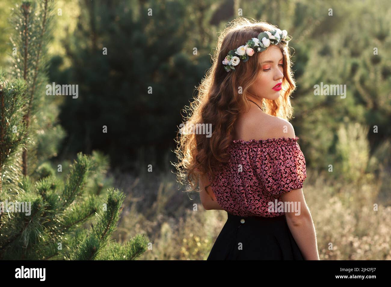 Beautiful girl standing in forest half-turned Stock Photo