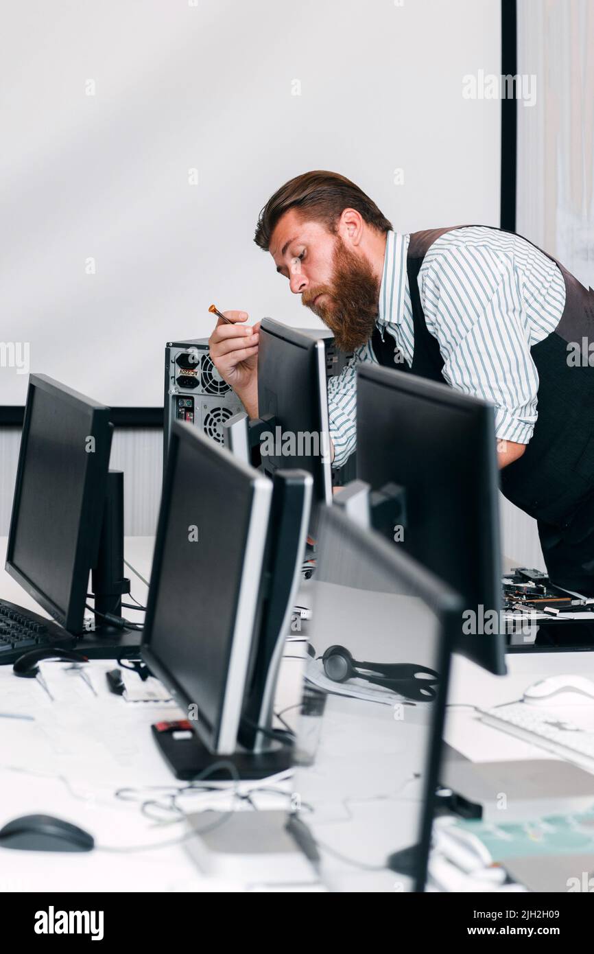 Repairman fixing computer monitor in office Stock Photo