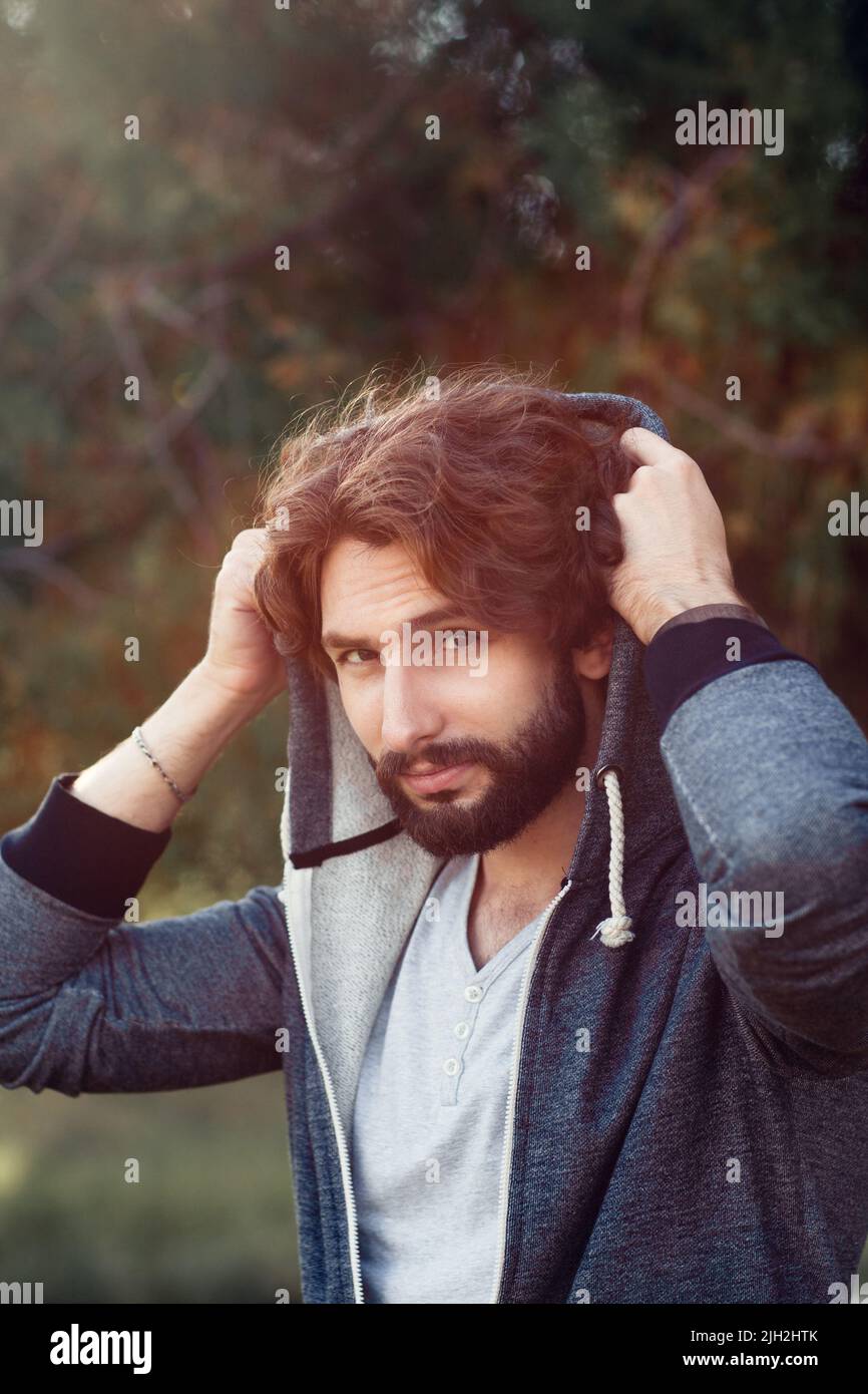 Portrait of attractive guy covering head Stock Photo